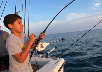 Boy fishing on back of charter fishing boat