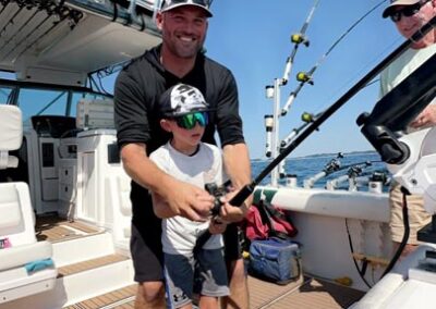 Father and son fishing on back of charter fishing boat